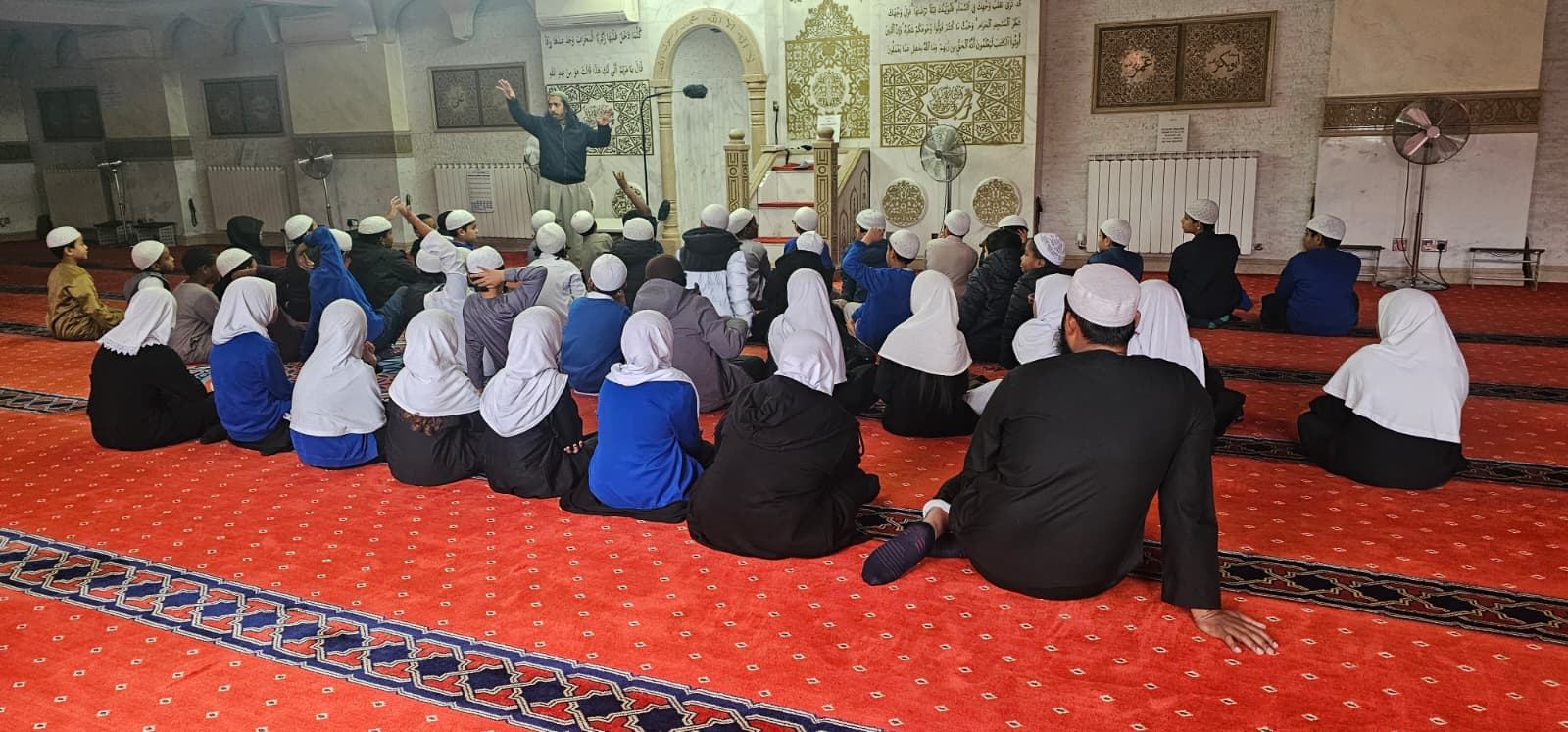 Pupils listening to a talk during a mosque visit